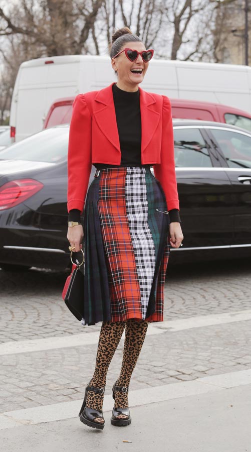 Biên tập viên Giovanna Battaglia Engelbert mặc áo khoác cổ lọ màu đỏ của Saint Laurent, chân váy tartan và quần tất họa tiết da báo.